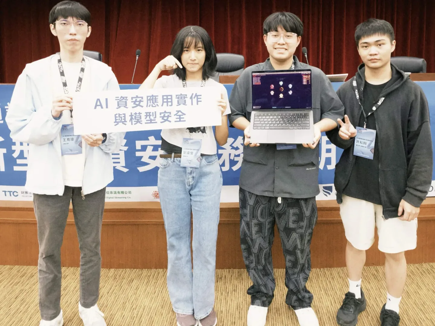 專題發表當天的組員合照，其中一台筆電顯示 AIAD 控制台
